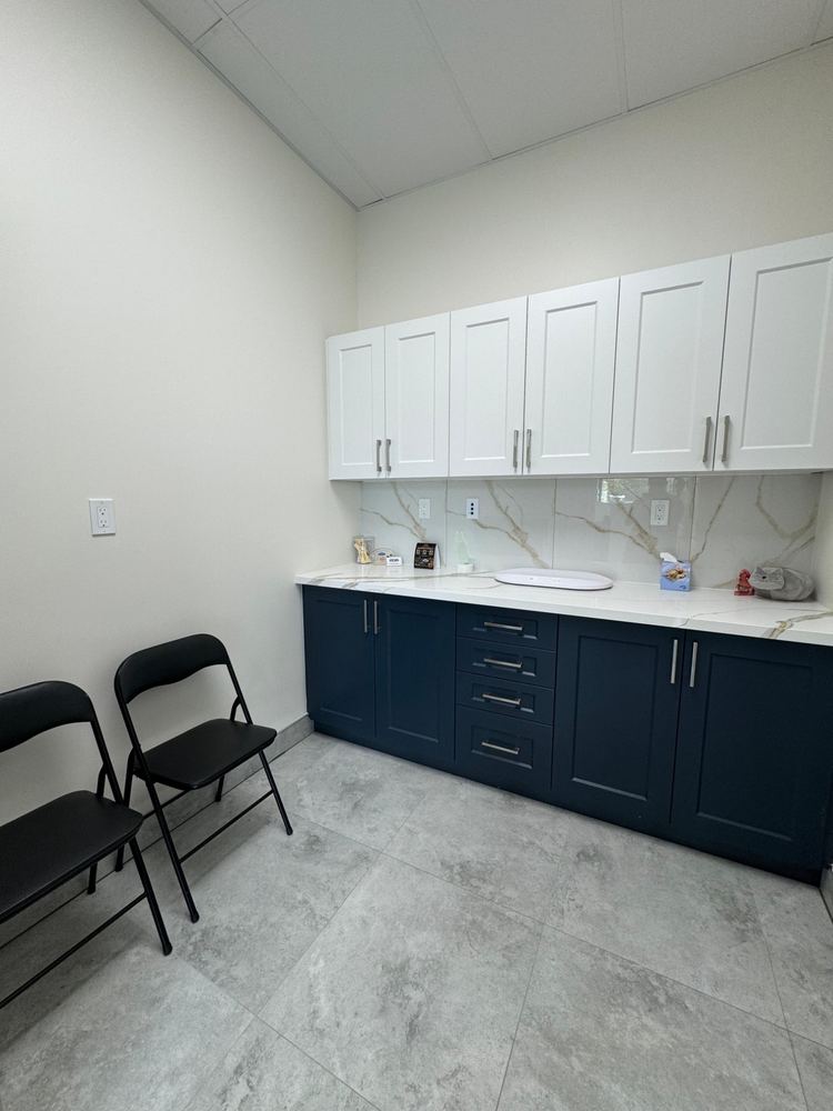 Exam room with a pet scale, cabinets and folding chairs